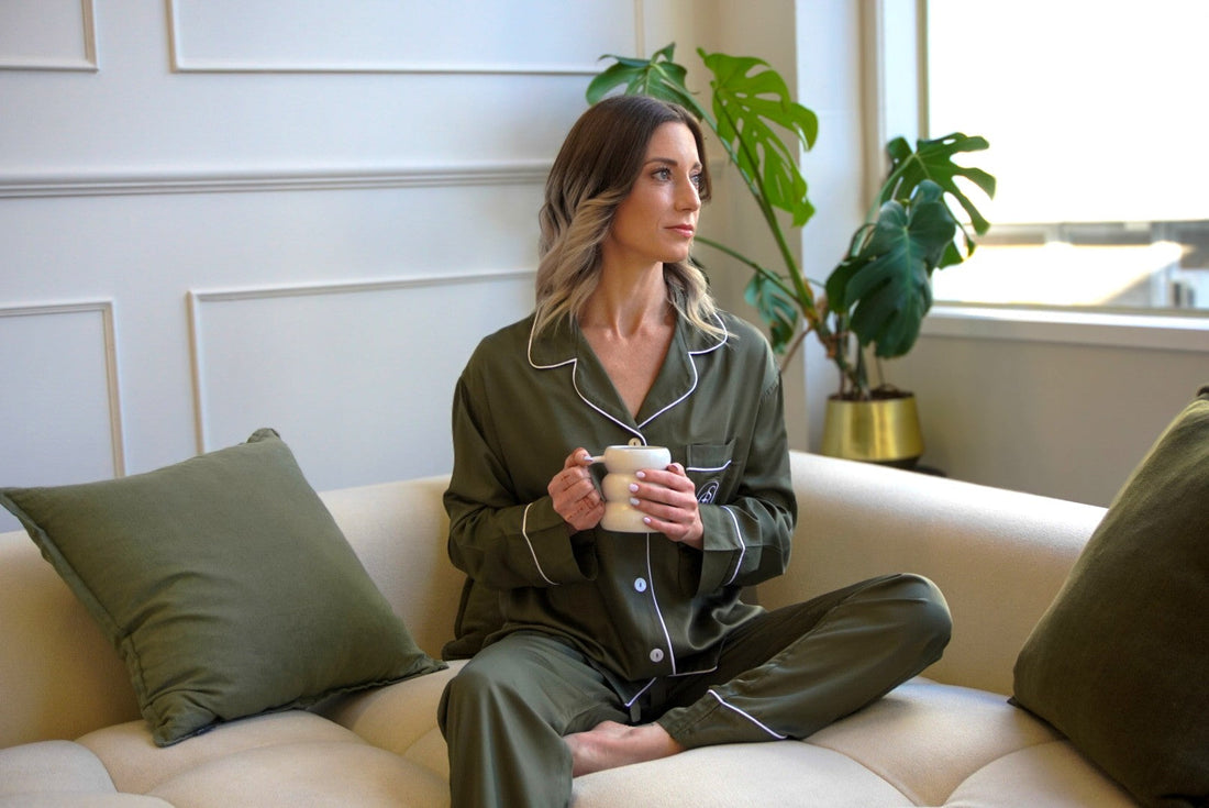 Woman wearing olive bamboo pjs holding a cup of drink.